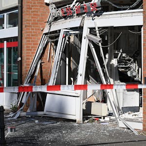 Ein zerstörter, explodierter Geldautomat an der Dürener Straße hinter rot-weißem Absperrband.