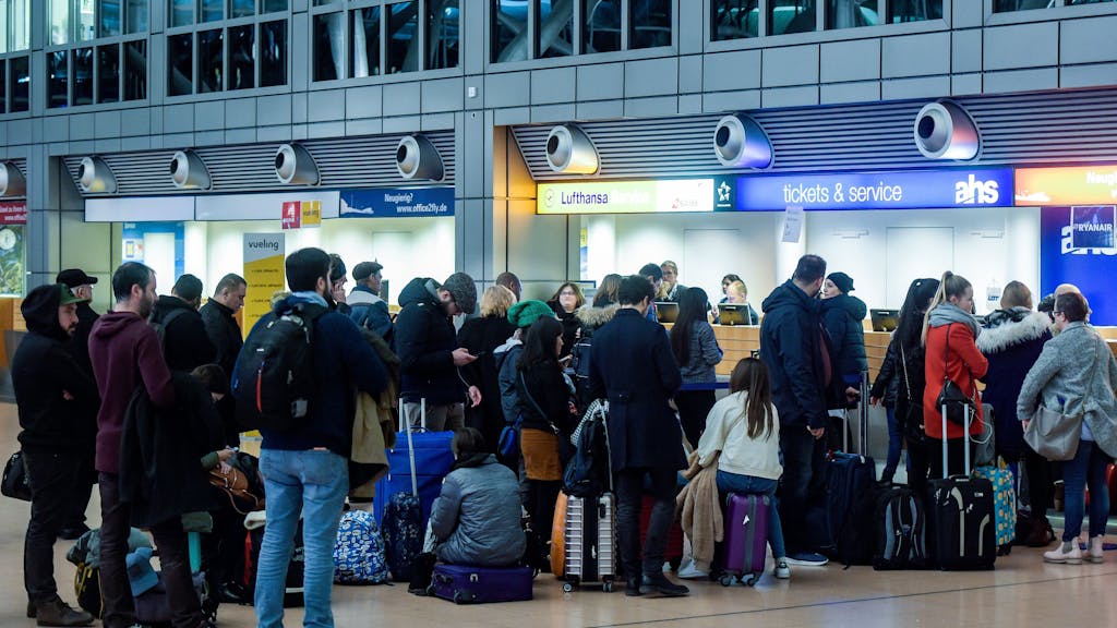 Fluggäste warten am 4. Februar 2019 in der Abflughalle des Flughafens in Hamburg vor einem Ticketschalter.