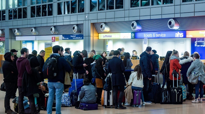 Fluggäste warten am 4. Februar 2019 in der Abflughalle des Flughafens in Hamburg vor einem Ticketschalter.