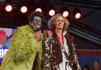 Isabella Neven DuMont und Christian DuMont Schütte stehen dicht nebeneinander im Kostüm auf der Bühne.