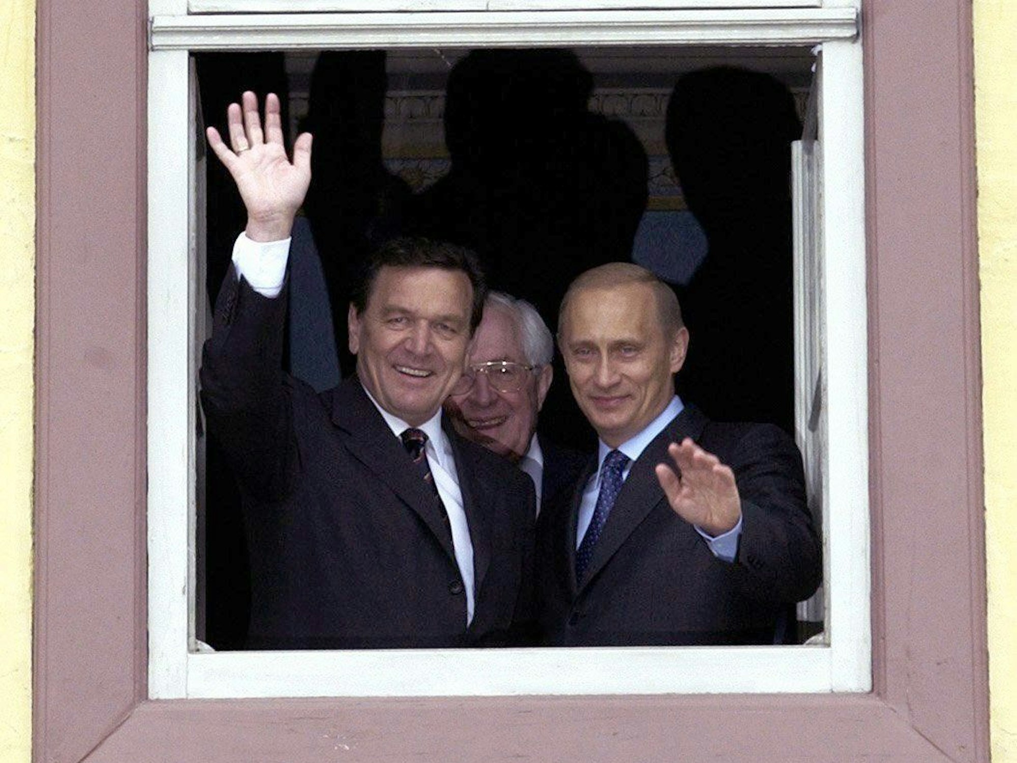 Bundeskanzler Gerhard Schröder (l) und der russische Präsident Wladimir Putin winken während ihrer Besichtigung der Innenstadt von Weimar aus einem Fenster des Goethe-Hauses.