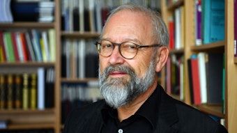 Herfried Münkler, emeritierter Professor für Politikwissenschaft an der Berliner Humboldt-Universität, steht vor Bücherregalen und schaut in die Kamera.