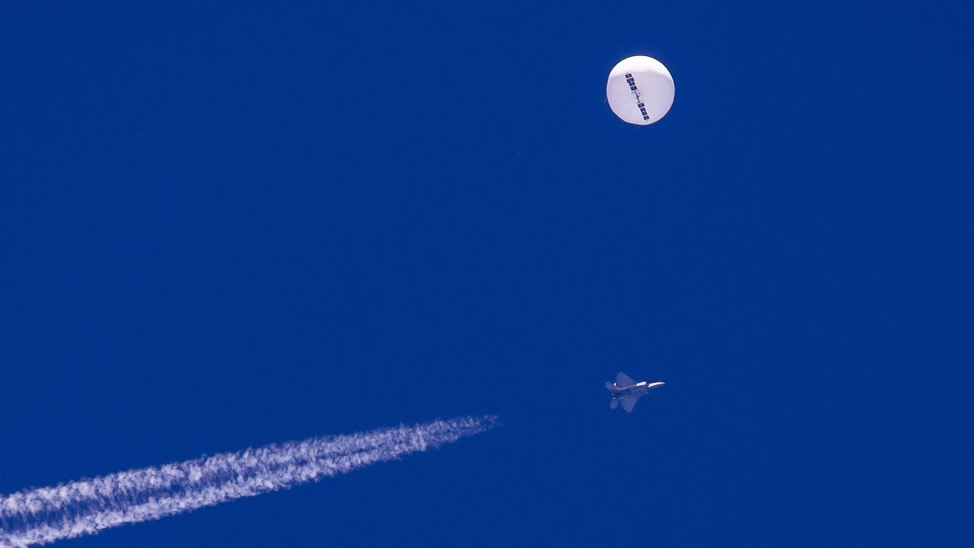 Auf diesem von Chad Fish zur Verfügung gestellten Bild schwebt ein großer Ballon über dem Atlantischen Ozean vor der Küste von South Carolina. Darunter sind ein Kampfjet und seine Kondensstreifen zu sehen.