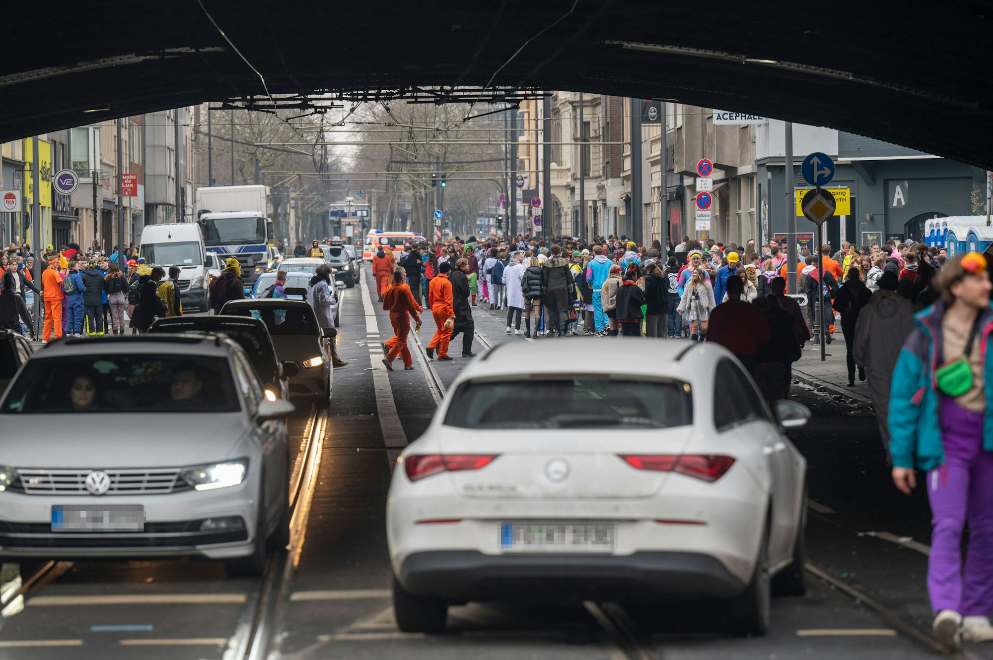 Hunderte Menschen laufen über die Luxemburger Straße und sind teilweise auch auf der Fahrbahn unterwegs. Autos bewegen sich langsam durch die Menschenmenge.