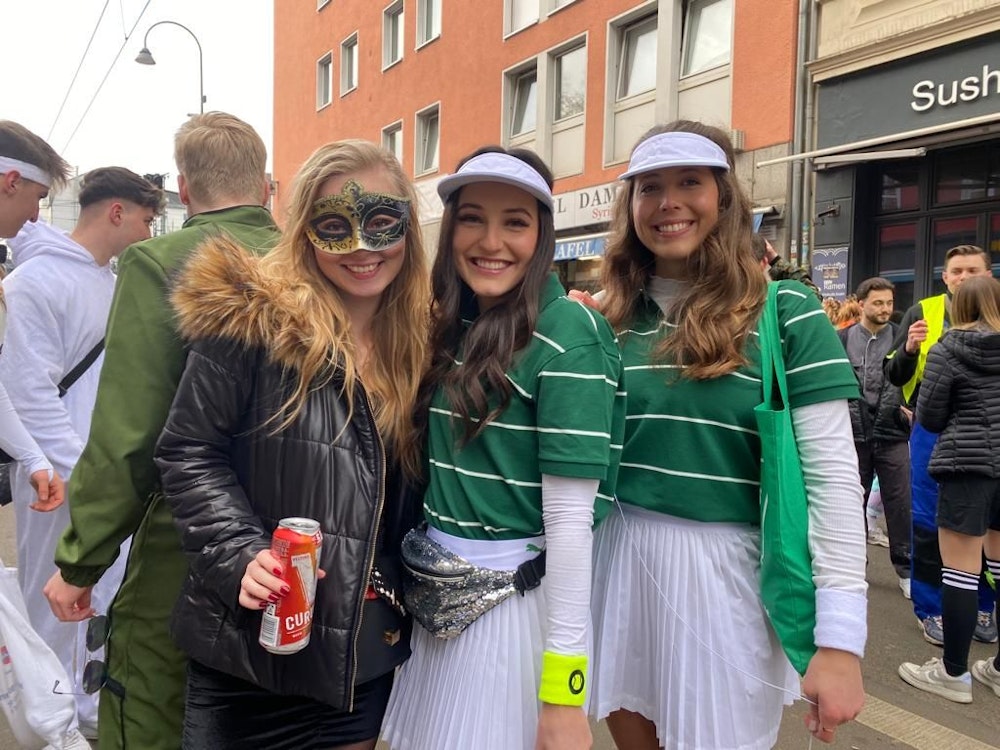 Drei kostümierte junge Frauen feiern Karneval.