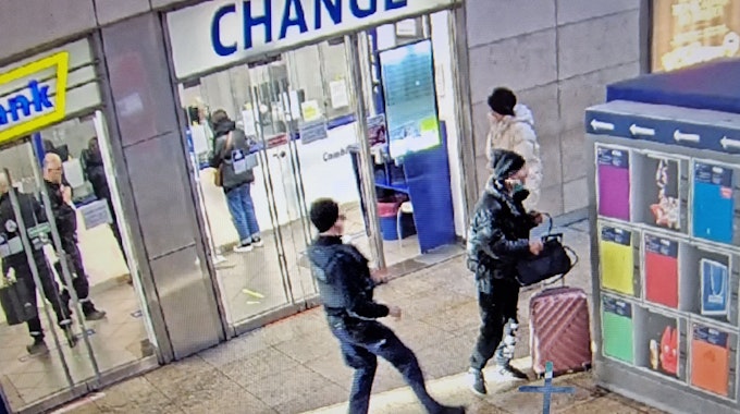 Ein mutmaßlicher Dieb hat die Tasche einer Reisenden gegriffen, während ein Bundespolizist keinen Meter von ihm entfernt ist.