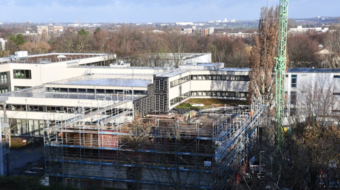 Das Foto zeigt das Ernst-Mach-Gymnasium in Hürth. Es ist wegen Bauarbeiten eingerüstet.