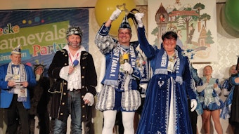 Das Prinzenpaar Mark und Tanja heben den symbolischen Rathausschlüssel hoch, neben ihnen steht auf der Bühne der Wolf kostümierte Bürgermeister Frank Steffes.
