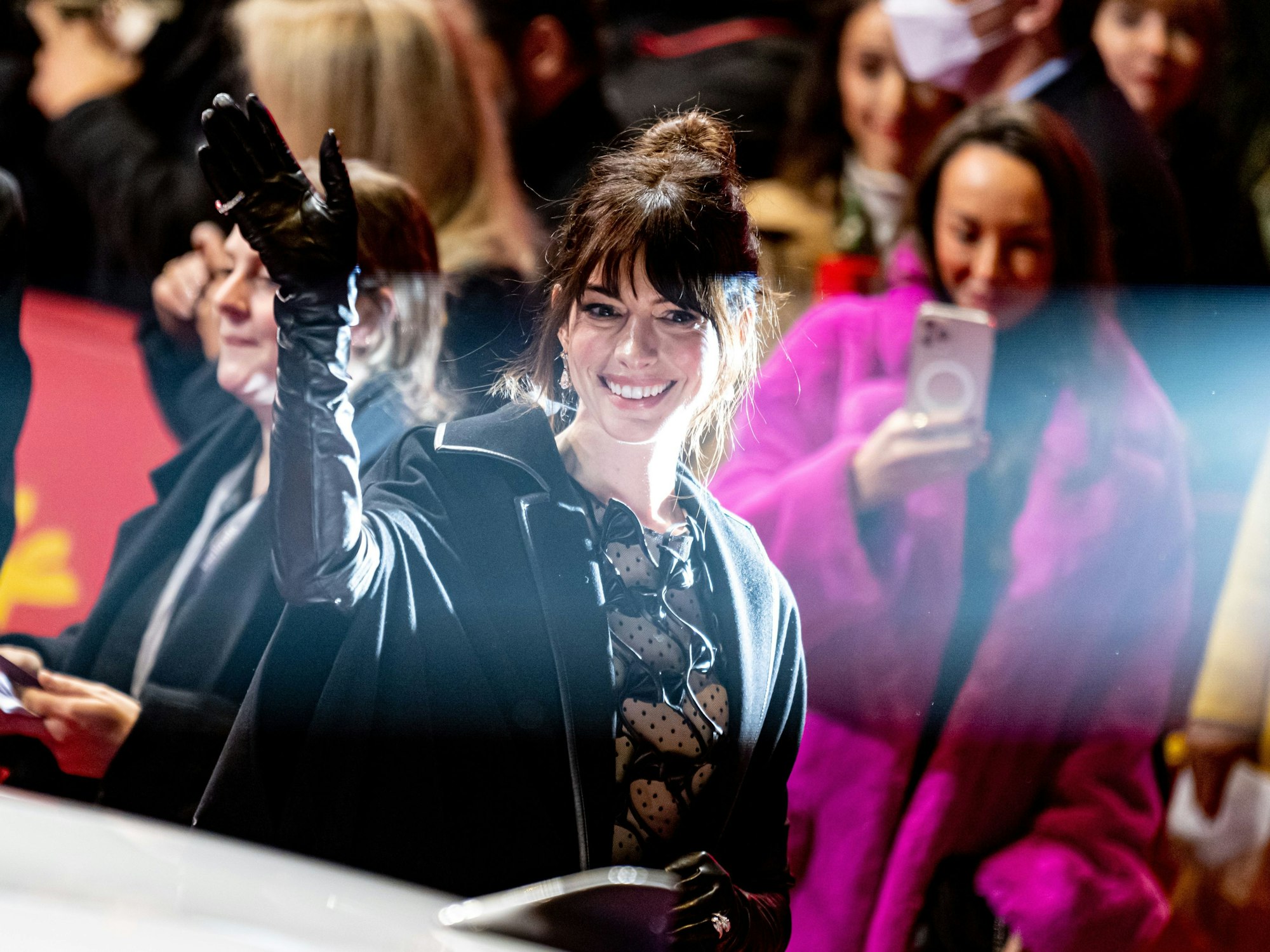 Anne Hathaway winkt den Fans.