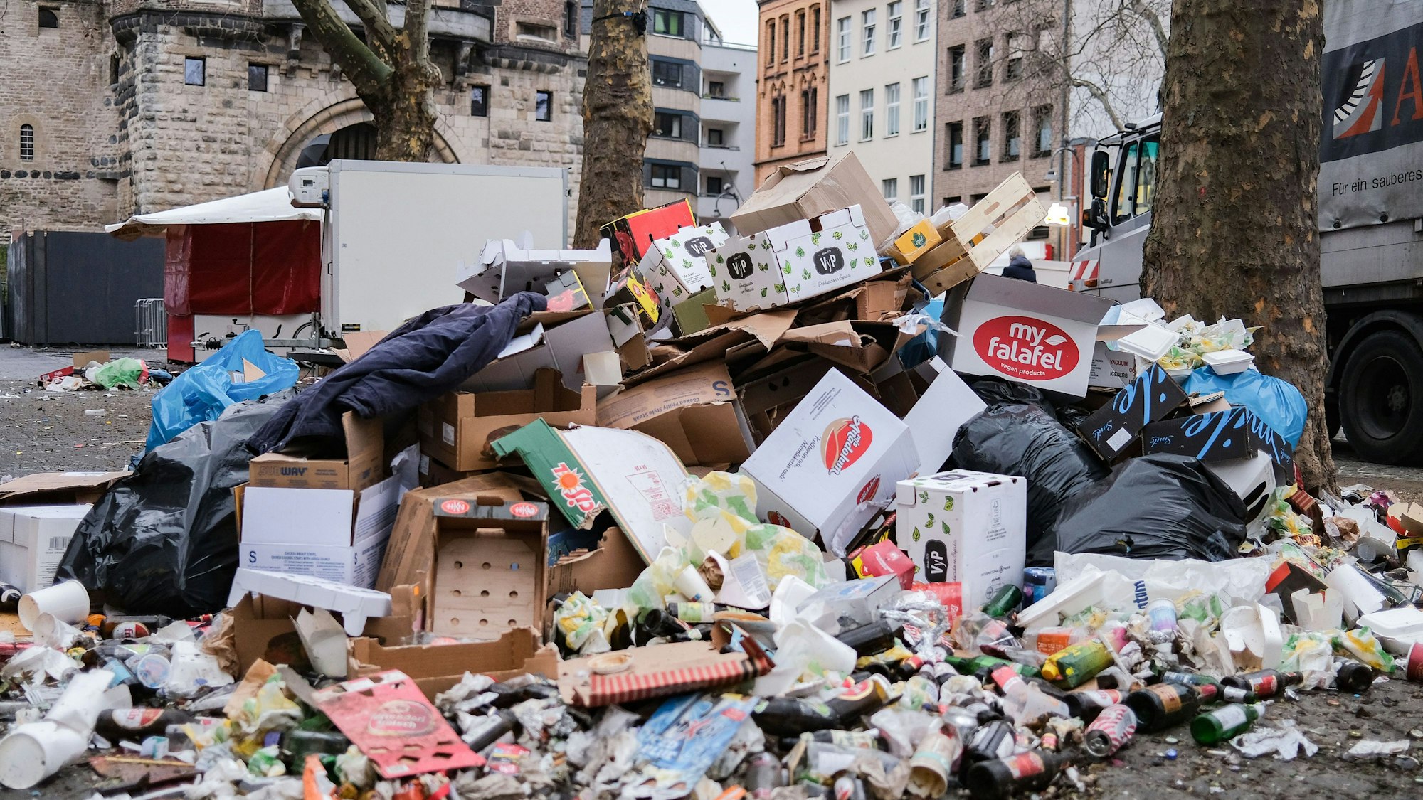 17.02.2023, Nordrhein-Westfalen, Köln: Zusammengefegter Müll aus der Weiberfastnacht liegt auf der Straße Mit der Weiberfastnacht hat der traditionelle Straßenkarneval begonnen. Foto: Oliver Berg/dpa +++ dpa-Bildfunk +++