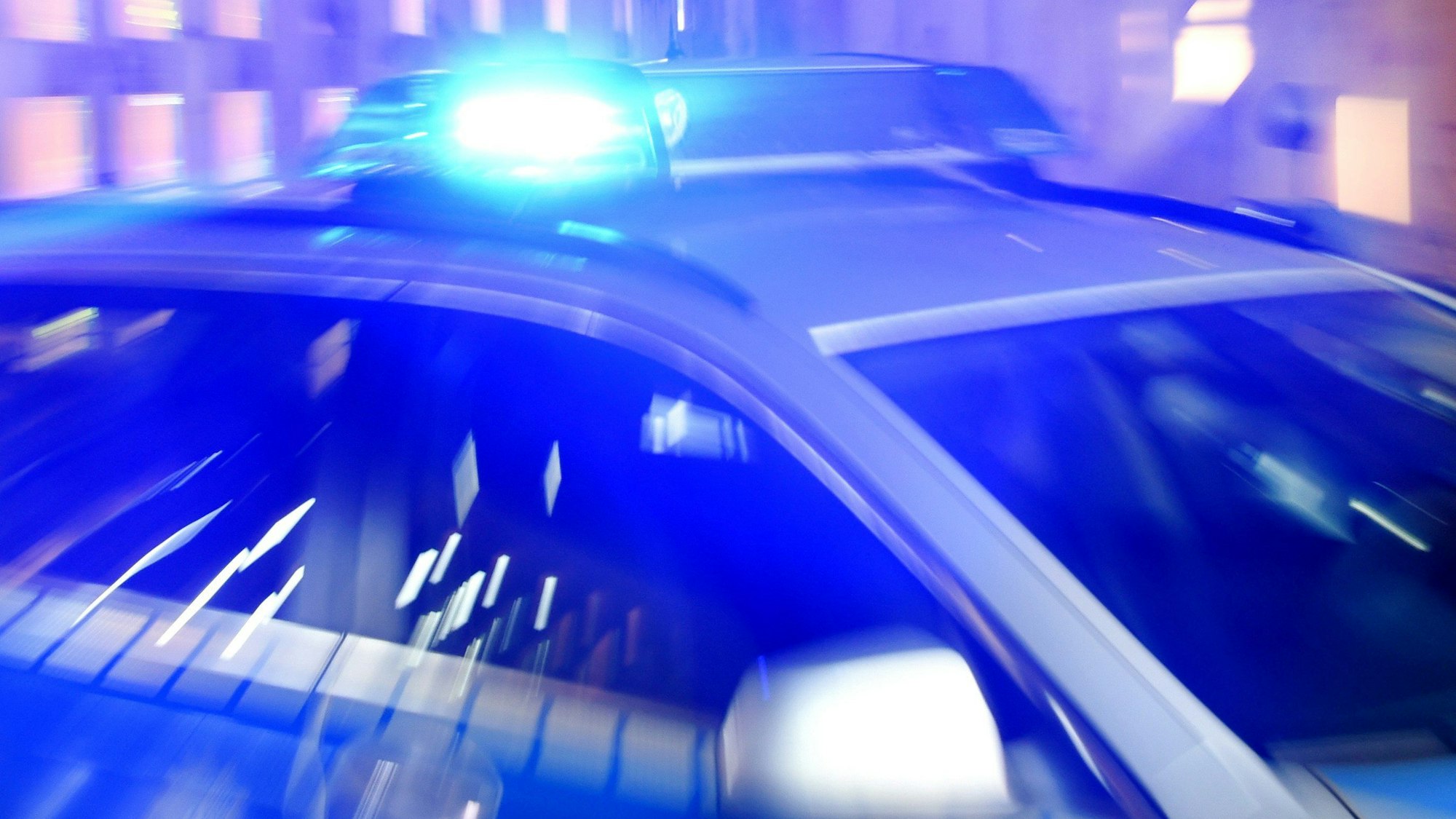 Ein Streifenwagen der Polizei steht mit eingeschaltetem Blaulicht auf der Straße. (Symbolbild)