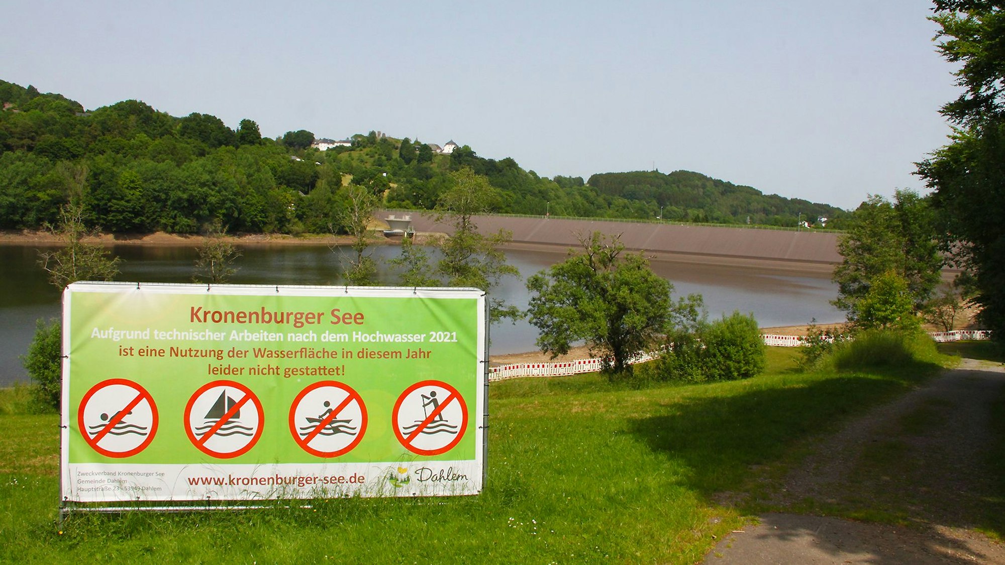 Vor dem Kronenburger See steht ein großes Schild, auf dem steht: „Aufgrund technischer Arbeiten nach dem Hochwasser 2021 ist eine Nutzung der Wasserfläche in diesem Jahr leider nicht gestattet.“