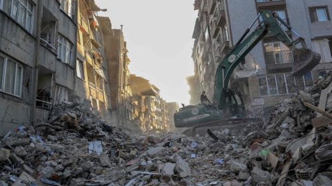 Ein Kran entfernt Schutt von zerstörten Gebäuden im türkischen Hatay