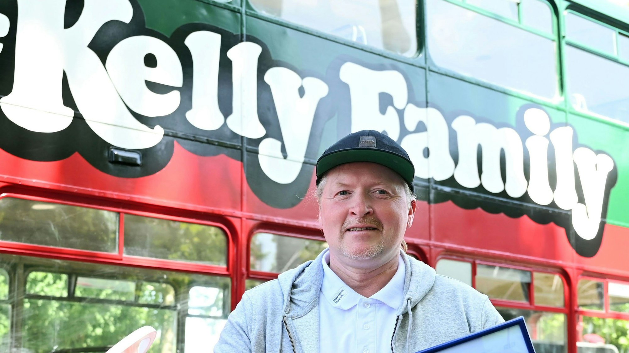 Der Sänger Joey Kelly steht vor dem Bus der Kelly-Family.