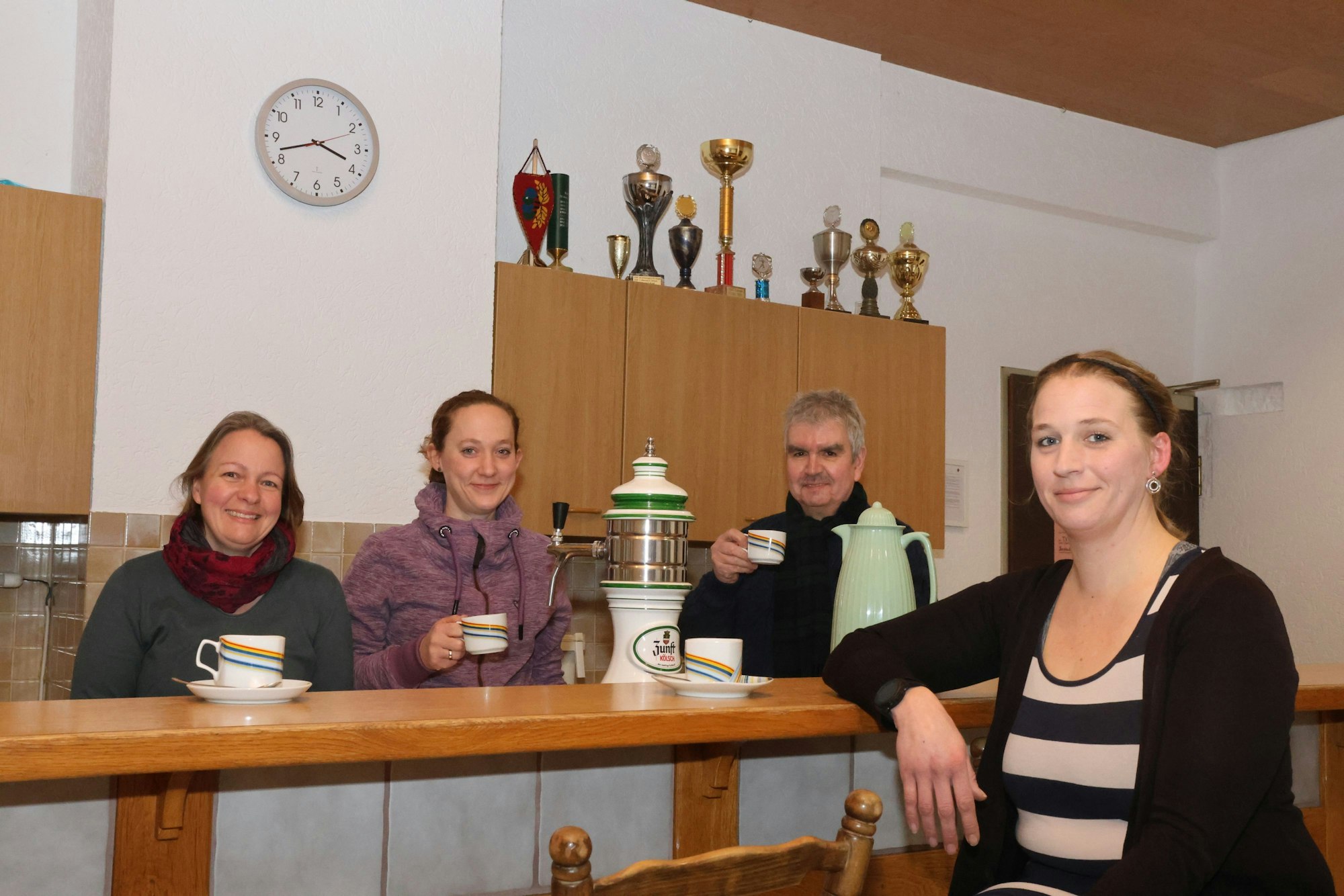 Vier Vertreter der Dorfgruppe Kotthausen stehen bei einer Tassee Kaffee zusammen.
