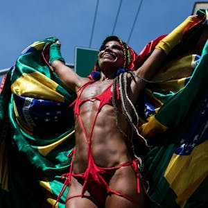 Ein Feiernder steht auf Stelzen umhüllt in einer brasilianischen Flagge während der Carmelitas-Straßenparty am ersten Tag des Karnevals in Rio De Janeiro.