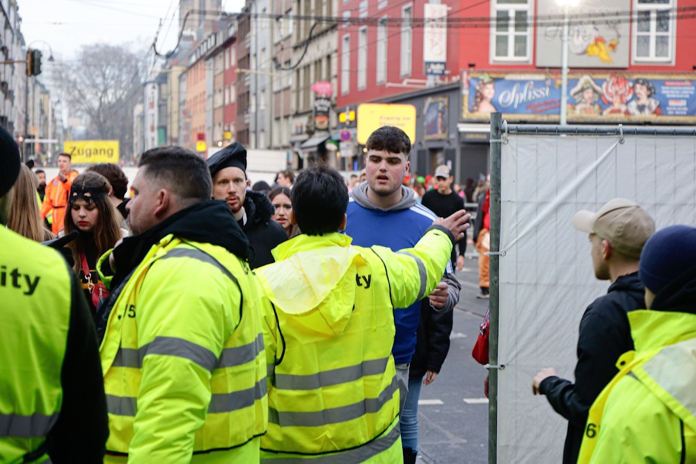 Sicherheitsdienstleute regeln den Zugang zur Zülpicher Straße an Karneval.