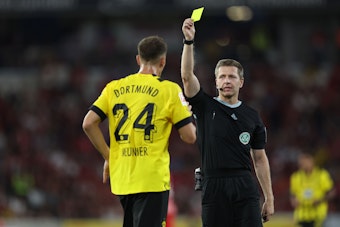 Schiedsrichter Tobias Welz zeigt Dortmunds Thomas Meunier die Gelbe Karte.