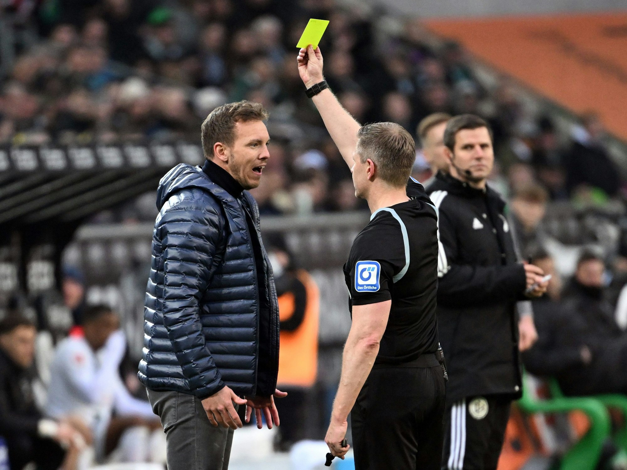 Schiedsrichter Tobias Welz zeigt Bayern-Trainer Julian Nagelsmann die Gelbe Karte.