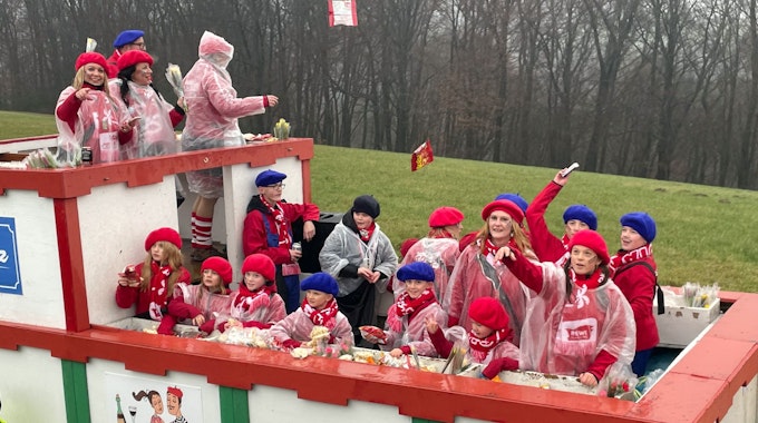 Eine Gruppe jubelt auf einem Karnevalswagen.