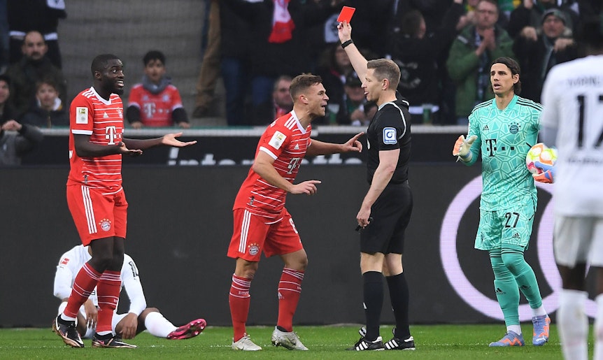Schiedsrichter Tobias Welz zeigt Dayot Upamecano (l.) von Bayern München die Rote Karte. Joshua Kimmich (2.v.l.) redet derweil auf den Unparteiischen wütend ein.