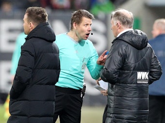 Schiedsrichter Patrick Ittrich (M) ermahnt Augsburgs Geschäftsführer Sport Stefan Reuter (r) im Beisein von Trainer Enrico Maaßen.