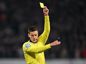 Schiedsrichter Daniel Siebert zeigt im Bundesliga-Spiel die Gelbe Karte.