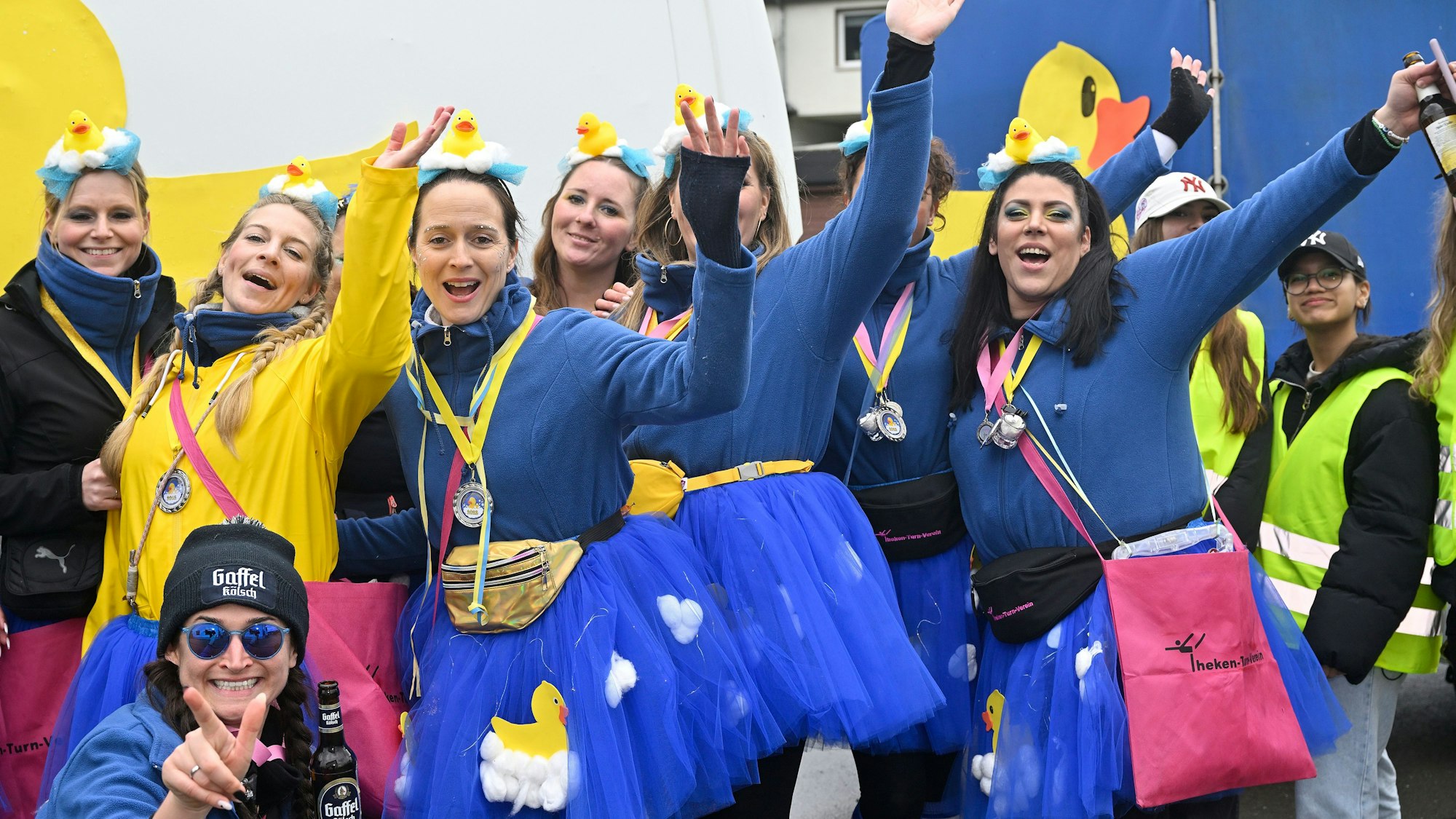 Jubelnde Frauen in blauen und gelben Kostümen.
