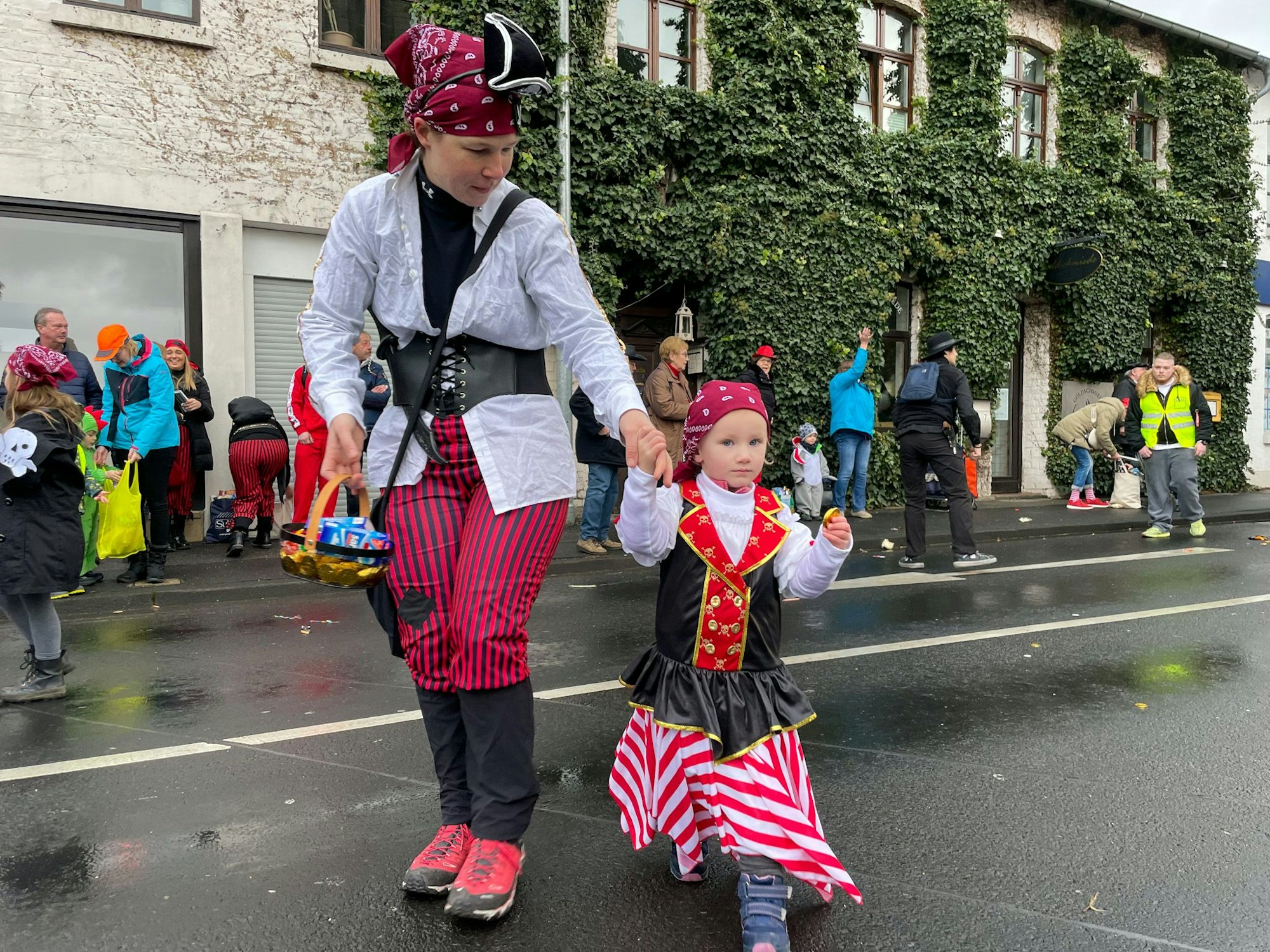 Eine Frau und ein kleines Mädchen sind als Piraten verkleidet und verteilen Kamelle.