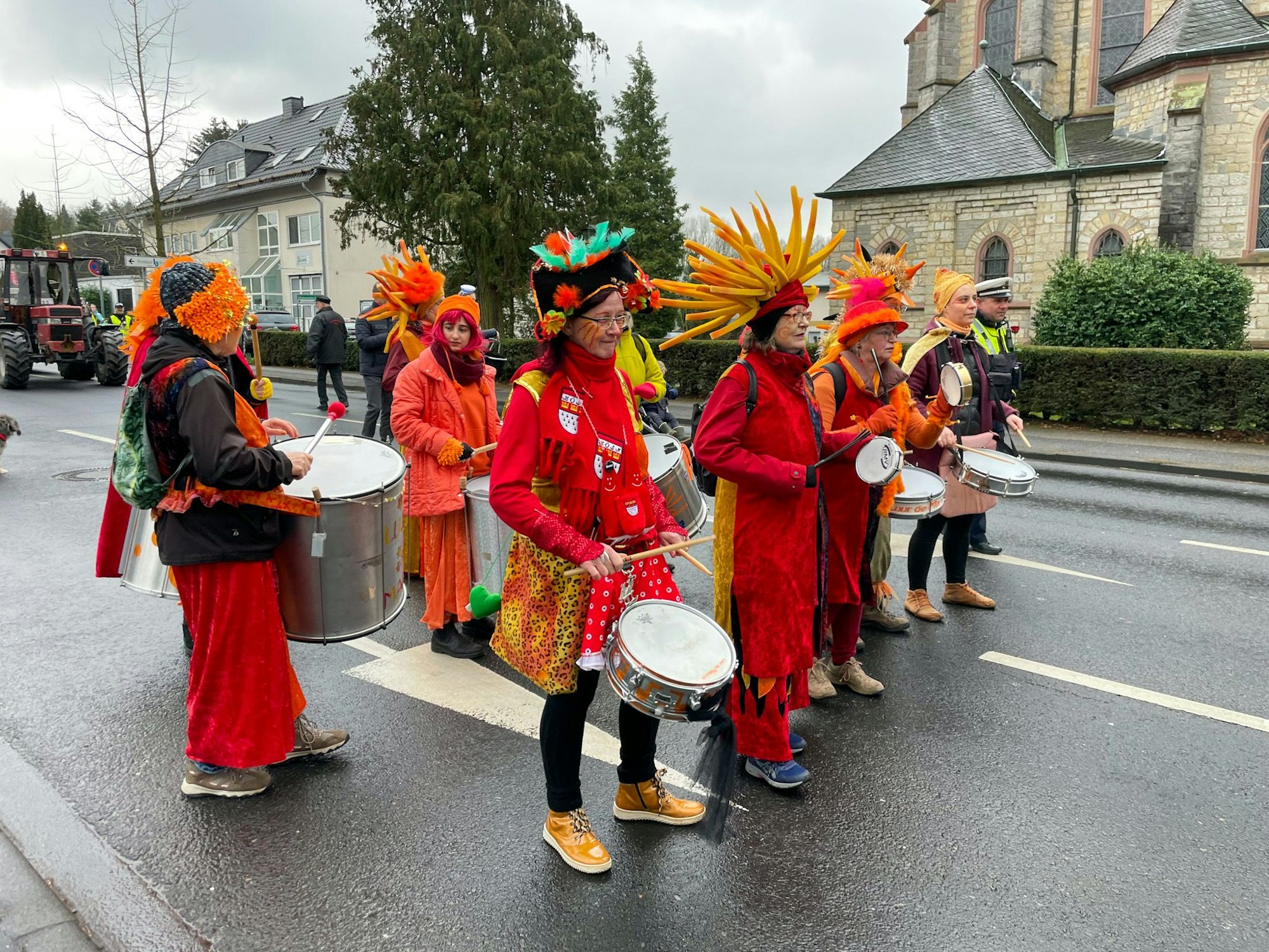 Eine Sambagruppe trägt orange Kostüme und Trommeln.