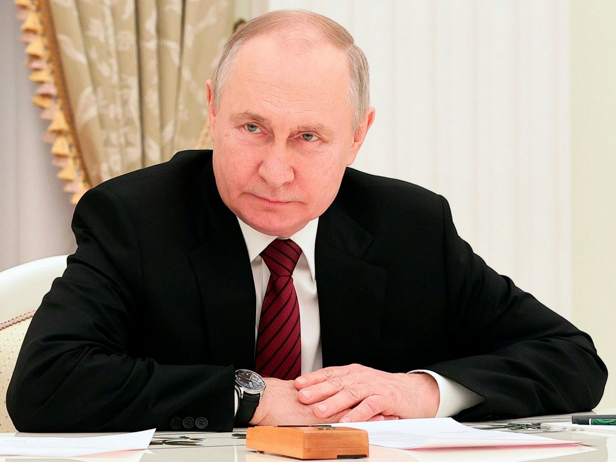 Das Foto von Februar 2023 zeigt den russischen Präsidenten Wladimir Putin. Er trägt einen schwarzen Anzug, vor ihm auf dem Tisch liegen Papiere.