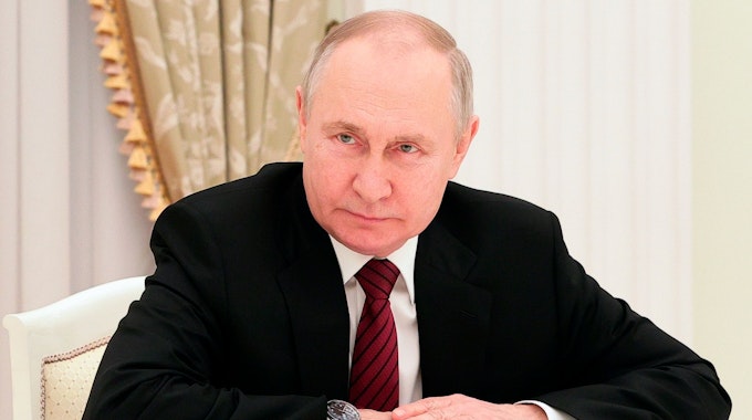 Das Foto von Februar 2023 zeigt den russischen Präsidenten Wladimir Putin. Er trägt einen schwarzen Anzug, vor ihm auf dem Tisch liegen Papiere.