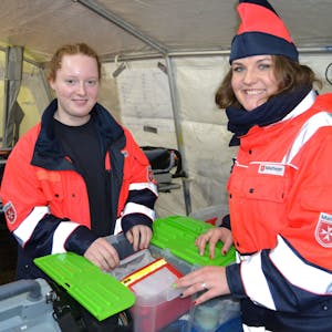 Blick auf zwei Sanitäterinnen, die ihre Ausrüstung prüfen.