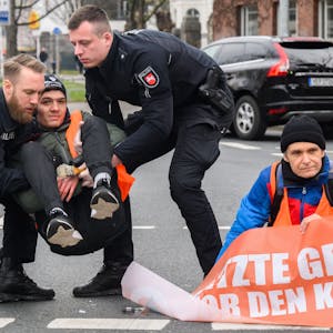 Hannover: Polizisten tragen zuvor am Asphalt festgeklebte Aktivisten der Gruppierung Letzte Generation von der Straße.