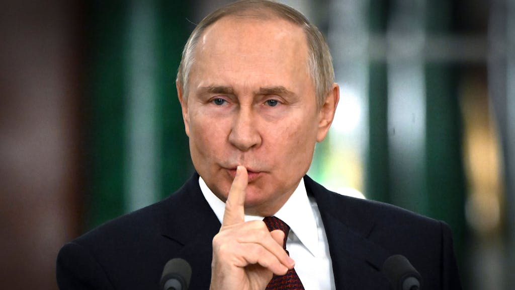 Wladimir Putin hält sich auf einer Pressekonferenz im Dezember 2022 in Moskau den Finger vor den Mund.
