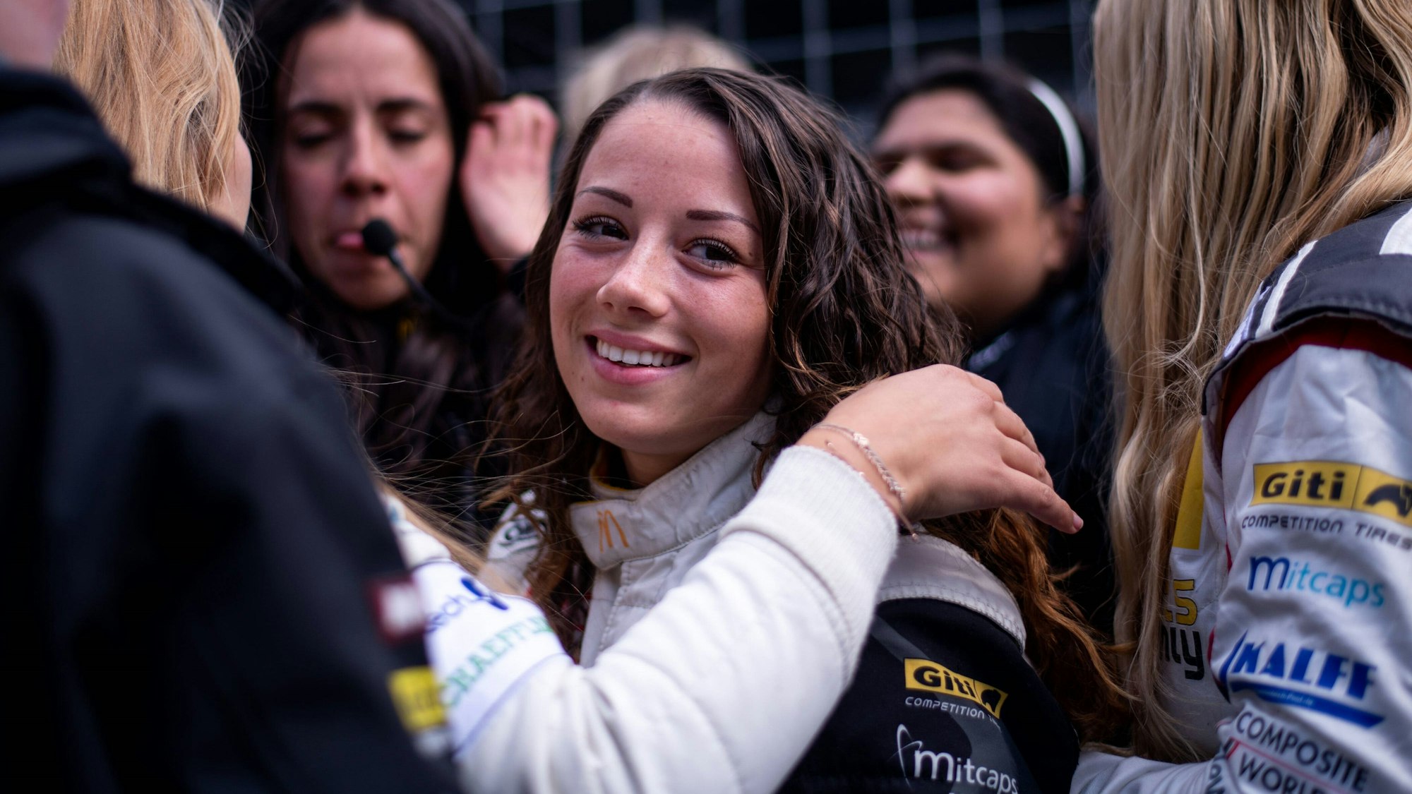Carrie Schreiner blickt beim 24-Stunden-Rennen auf dem Nürburgring in der Box in die Kamera.