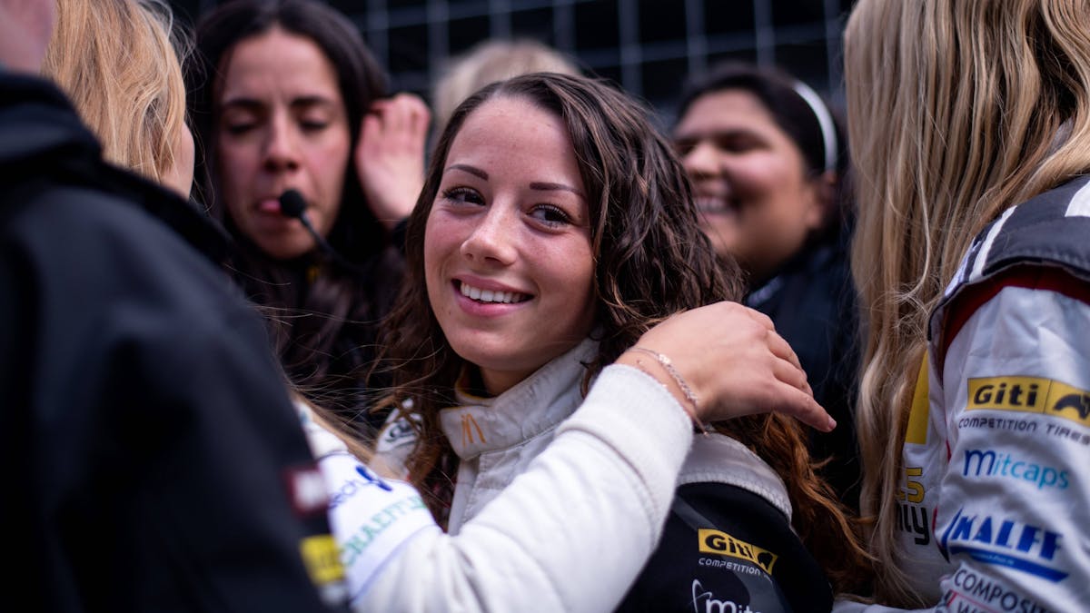 Carrie Schreiner blickt beim 24-Stunden-Rennen auf dem Nürburgring in der Box in die Kamera.