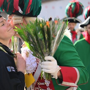 Eine Polizistin bekommt am Rande des Rosenmontagszuges ein Küsschen.