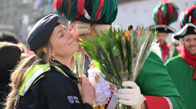 Eine Polizistin bekommt am Rande des Rosenmontagszuges ein Küsschen.&nbsp;