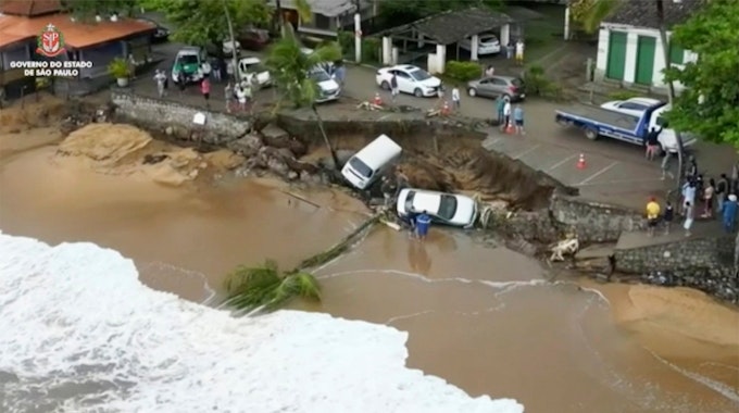 Dieses von der Regierung von São Paulo zur Verfügung gestellte Foto zeigt Fahrzeuge, die von einer Anhöhe entlang des Strandes in Sao Sebastiao, östlich von São Paulo, Brasilien, am Sonntag, dem 19. Februar 2023, heruntergestürzt sind.