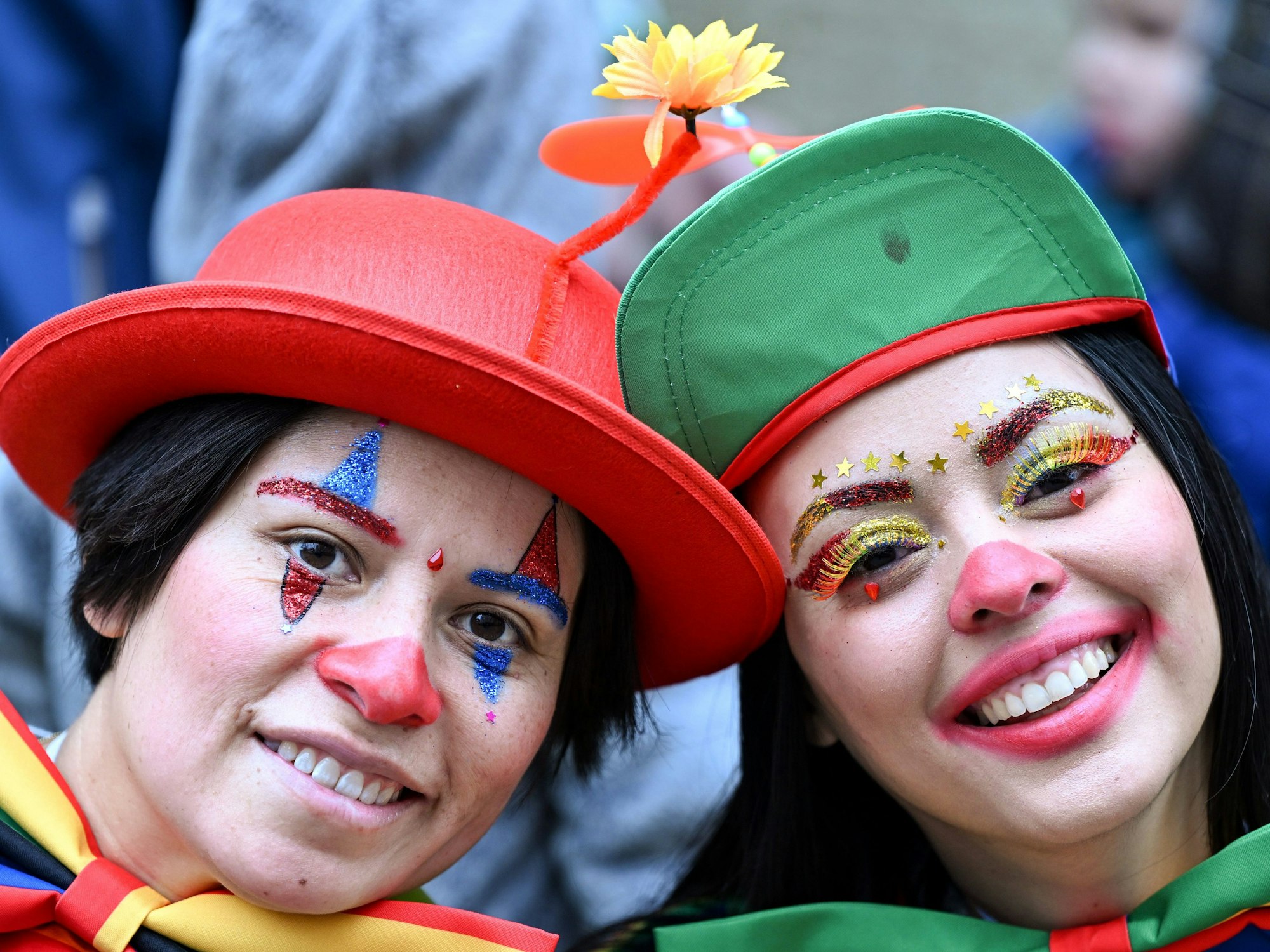 Kostümierter Karnevalistinnen stehen an der Strecke des Festumzugs.