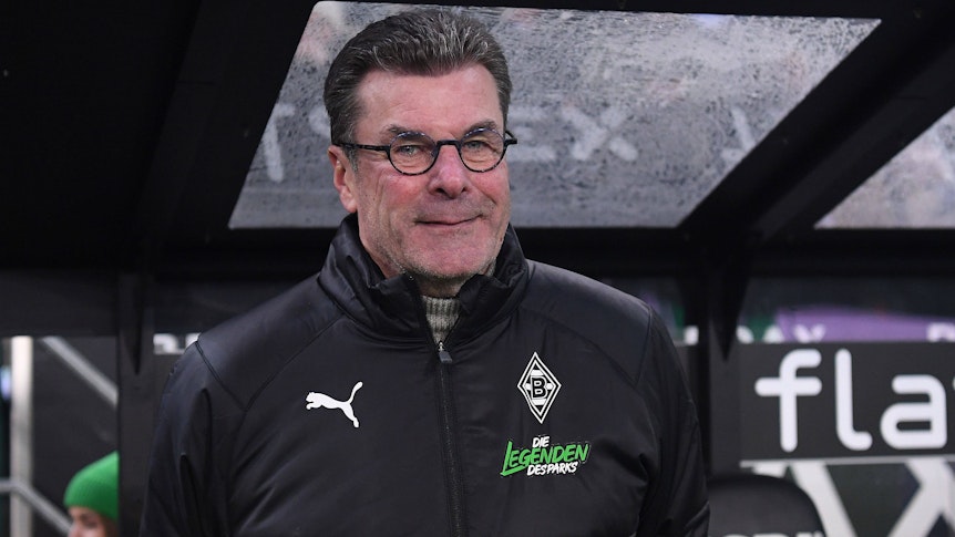 Ex-Gladbach-Coach Dieter Hecking kehrt auf die Trainerbank zurück. Der 58-Jährige, hier zu sehen an der Seitenlinie während des Legendenspiels (17. Dezember 2022) im Borussia-Park, übernimmt bei Zweitligist 1. FC Nürnberg das Amt bis zum Saisonende. Hecking trägt eine Brille, er lächelt.