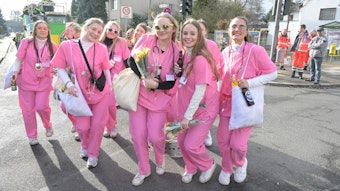 Eine Gruppe von Frauen ist in Rosa als Krankenschwestern verkleidet.