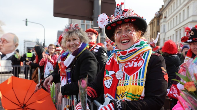 Verkleidete Frauen stehen beim Rosenmontagszug in Köln am Straßenrand und freuen sich ausgelassen über die gute Stimmung in der Stadt.