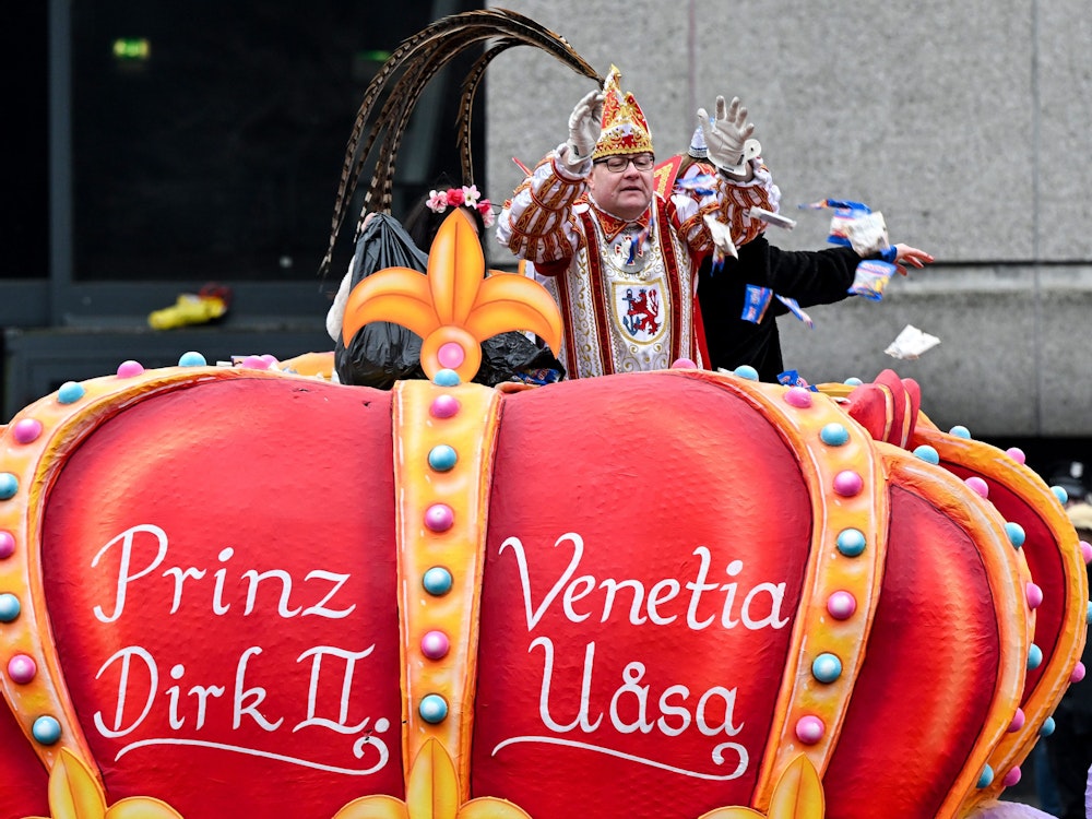 Karnevalsprinz Dirk II. wirft Süßigkeiten von einem Wagen.