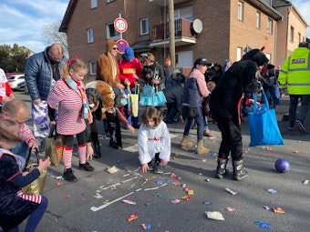 Kinder sammeln Kamelle bei einem Karnevalszug in Troisdorf.