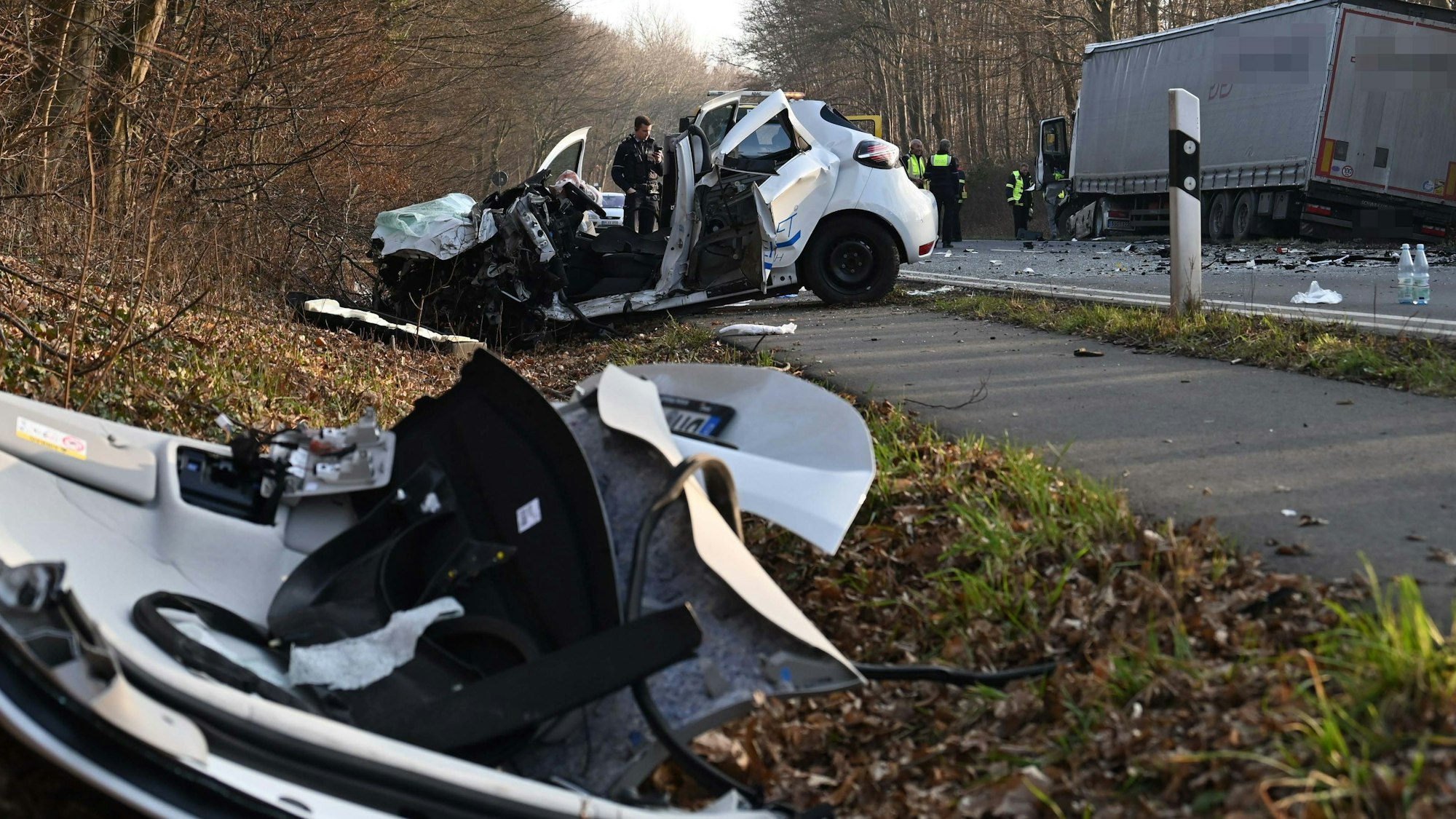 Das Bild zeigt einen total beschädigten Kleinwagen am Straßenrand und mehrere Einsatzkräfte auf der gesperrten Luxemburger Straße