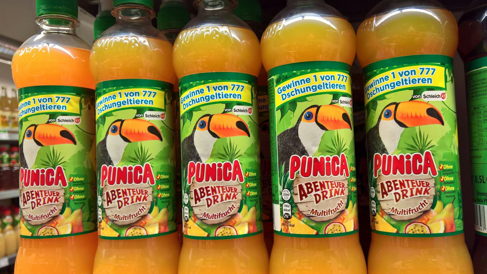 Mehrere Punica-Flaschen mit der Aufschrift „Punica Abenteuer-Drink“ sind in einem Supermarkt-Regal zu sehen.