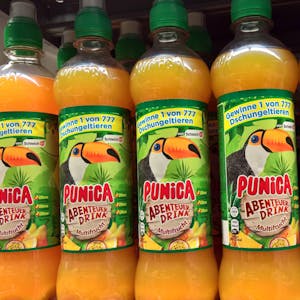 Mehrere Punica-Flaschen mit der Aufschrift „Punica Abenteuer-Drink“ sind in einem Supermarkt-Regal zu sehen.