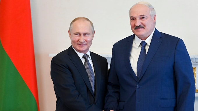 Wladimir Putin (l) und Alexander Lukaschenko geben sich die Hand.